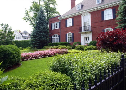 front fenced in yard with gardens