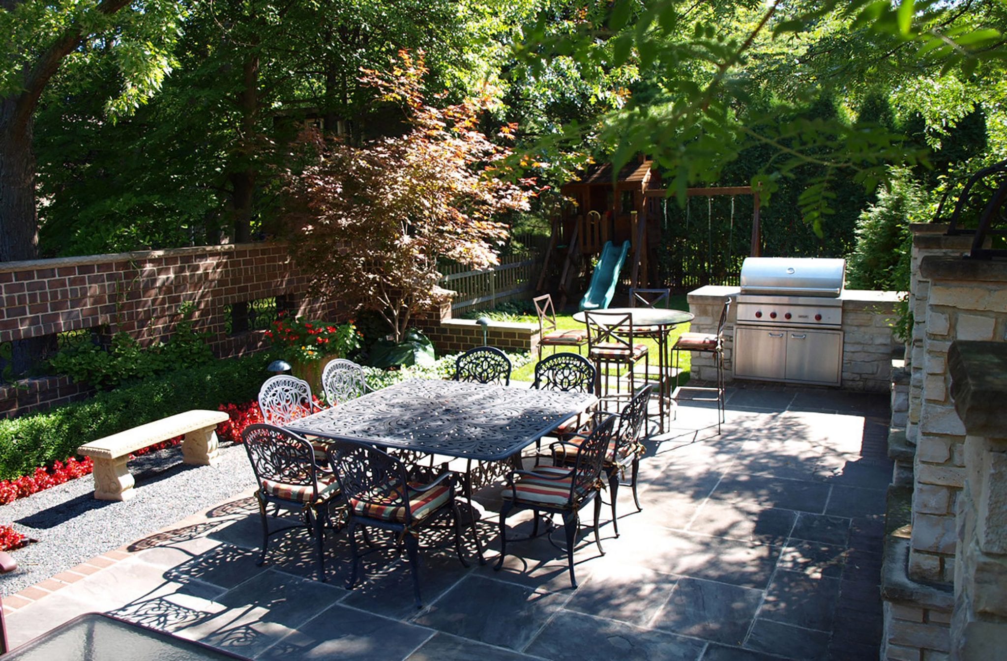 small backyard with outdoor kitchen and swing set