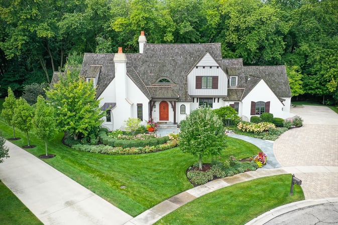 Front of nice house with green lawn, landscaping and paver driveway