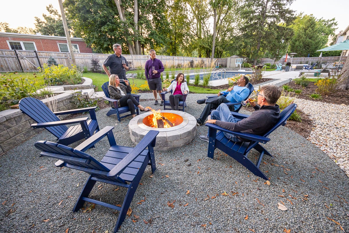 Residential landscape design family sitting around fire pit 