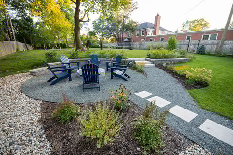 Residential landscape design log firepit area with seating 