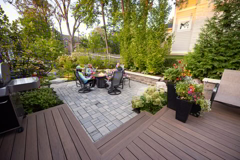 residential landscape design family sitting around fire 