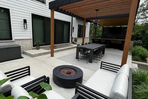 Residential backyard with gazebo patio cover and bushes next to the patio