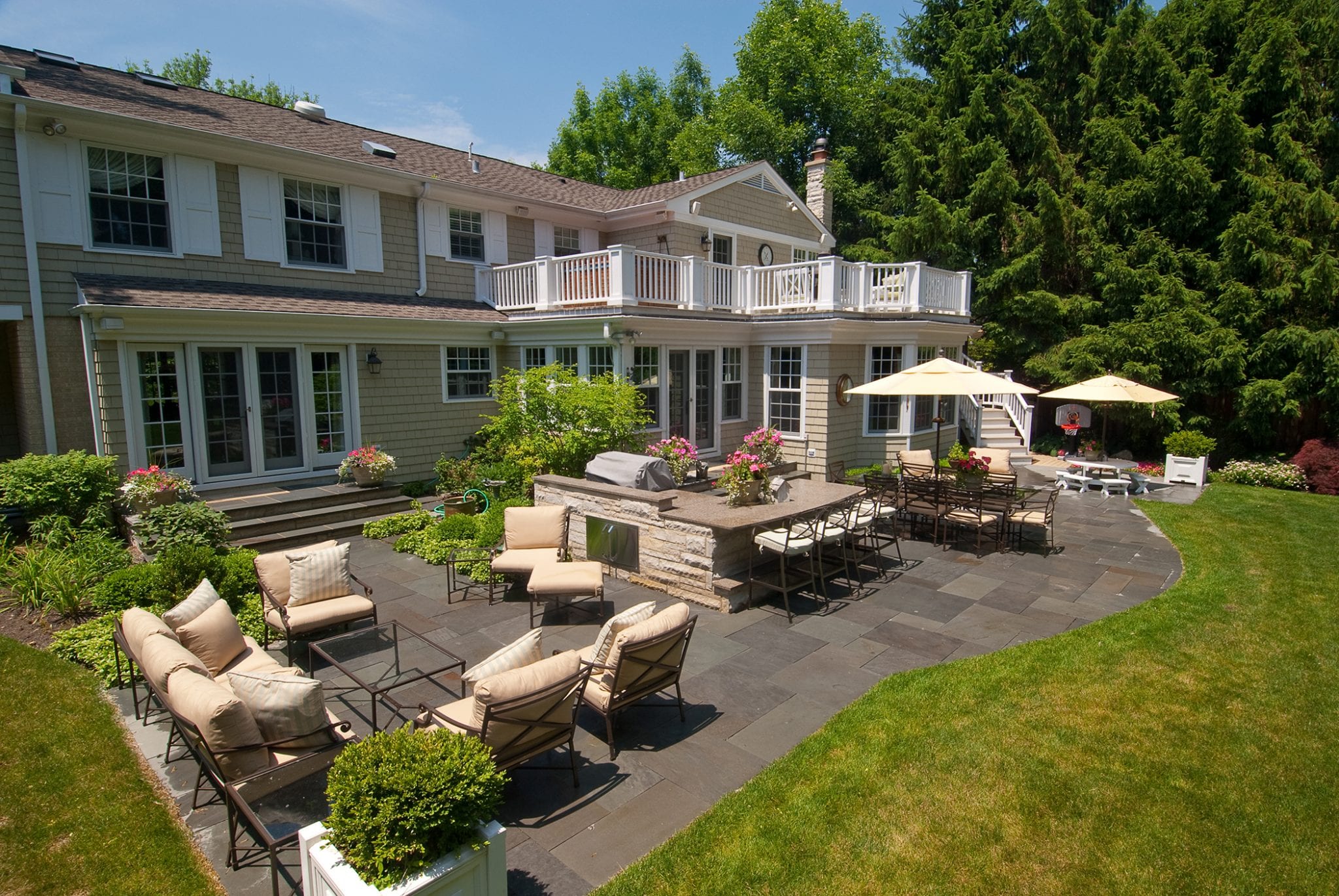 falgstone patio in backyard with outdoor kitchen and seating area 