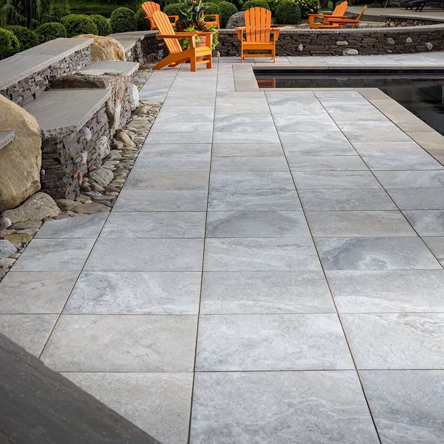 paver patio surrounding pool in backyard