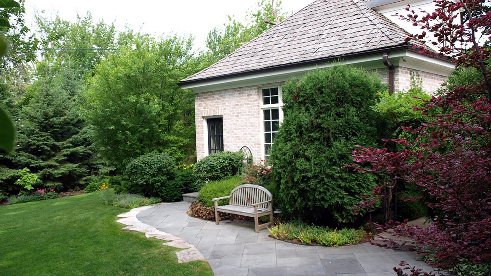 back yard with bench overlooking green lawn