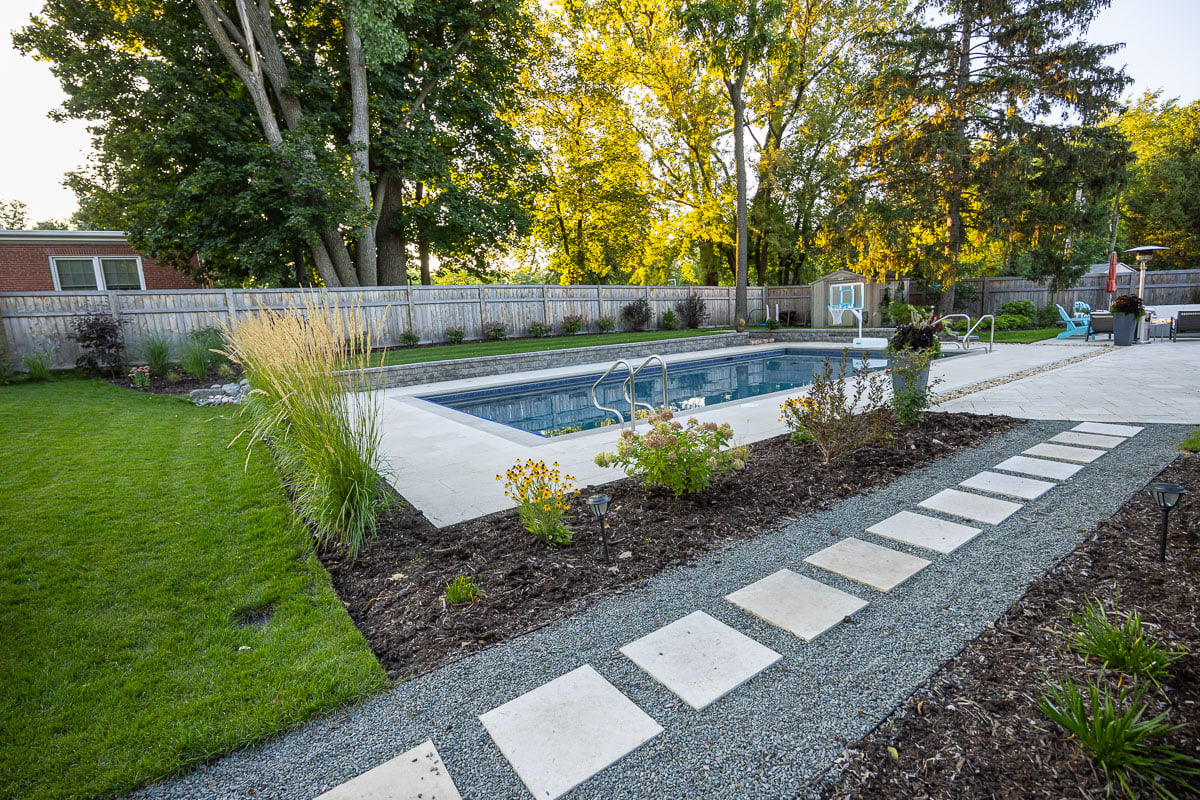 Residential landscape design paver walkway leading to pool and patio