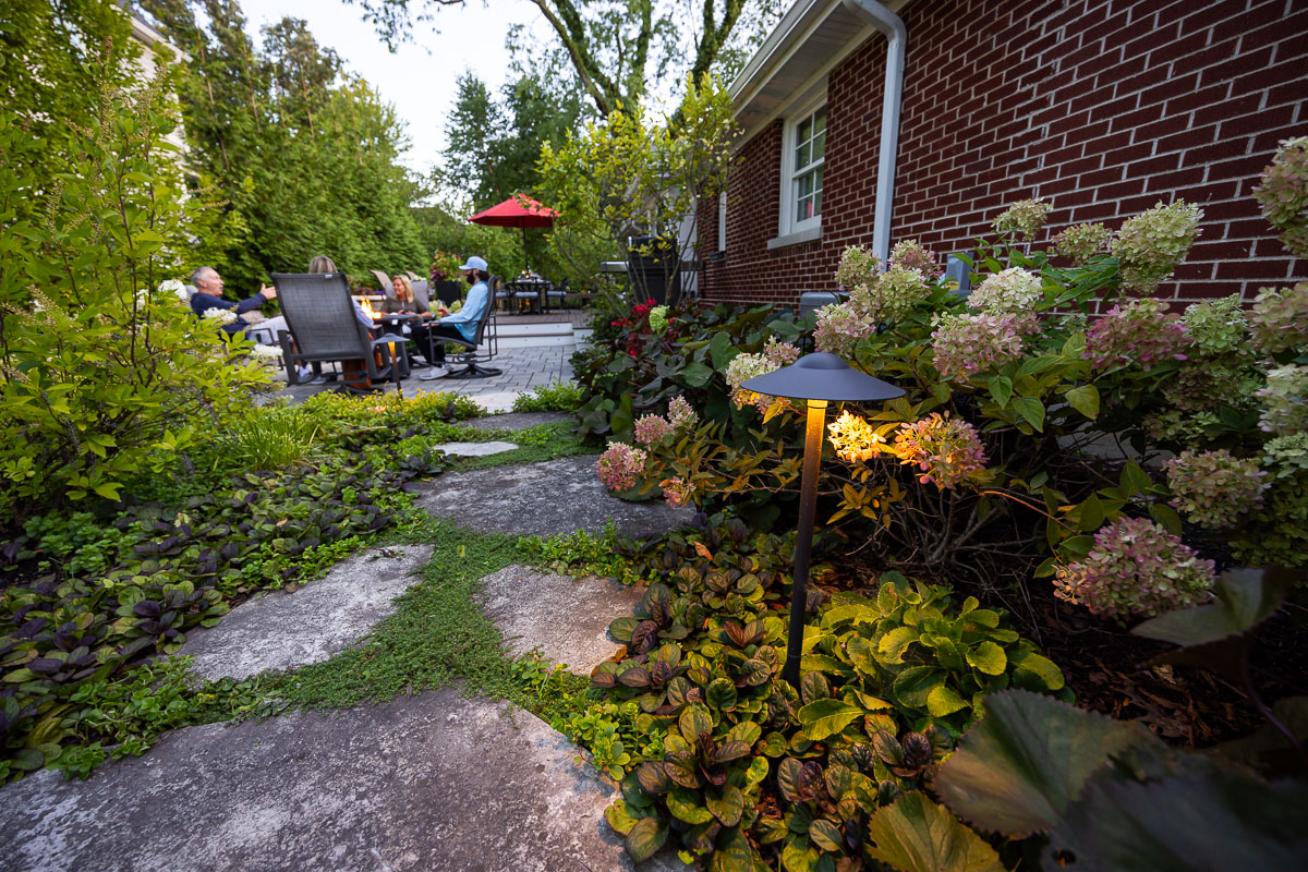 residential landscape design family sitting around fire 1-1