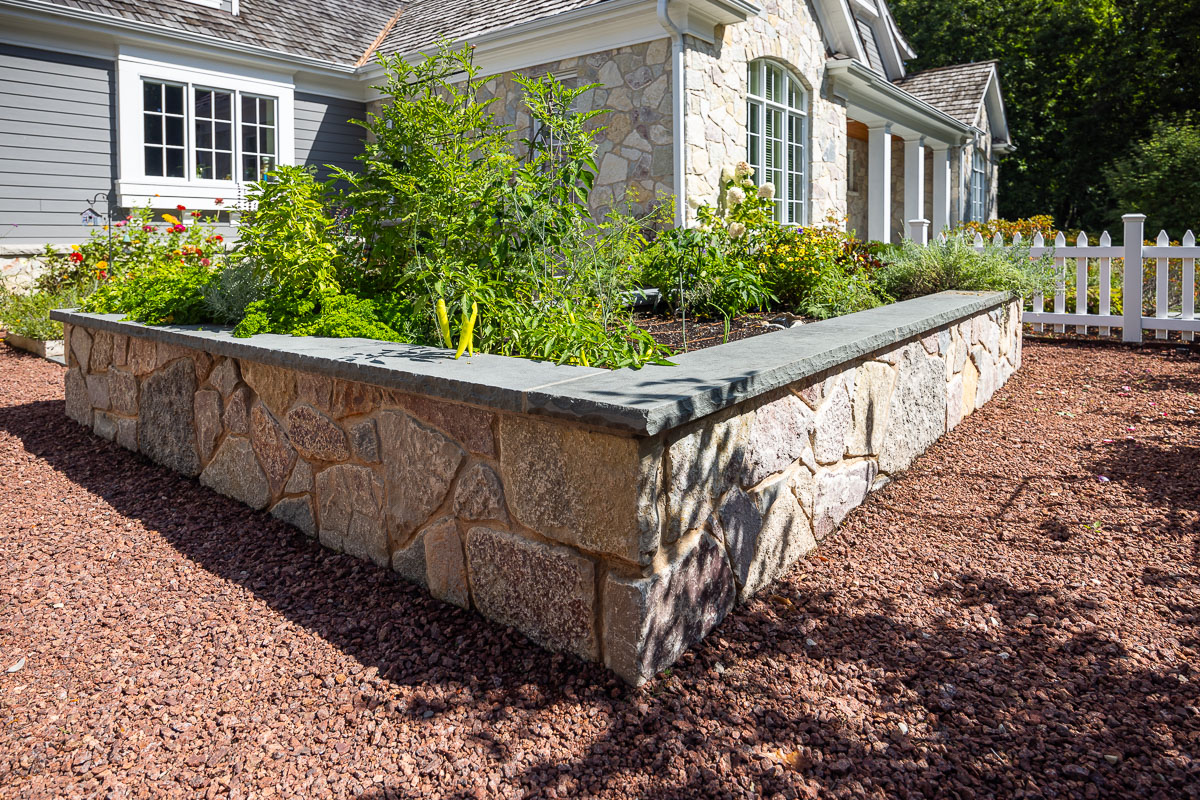 residential landscape design with veggie garden and retaining wall