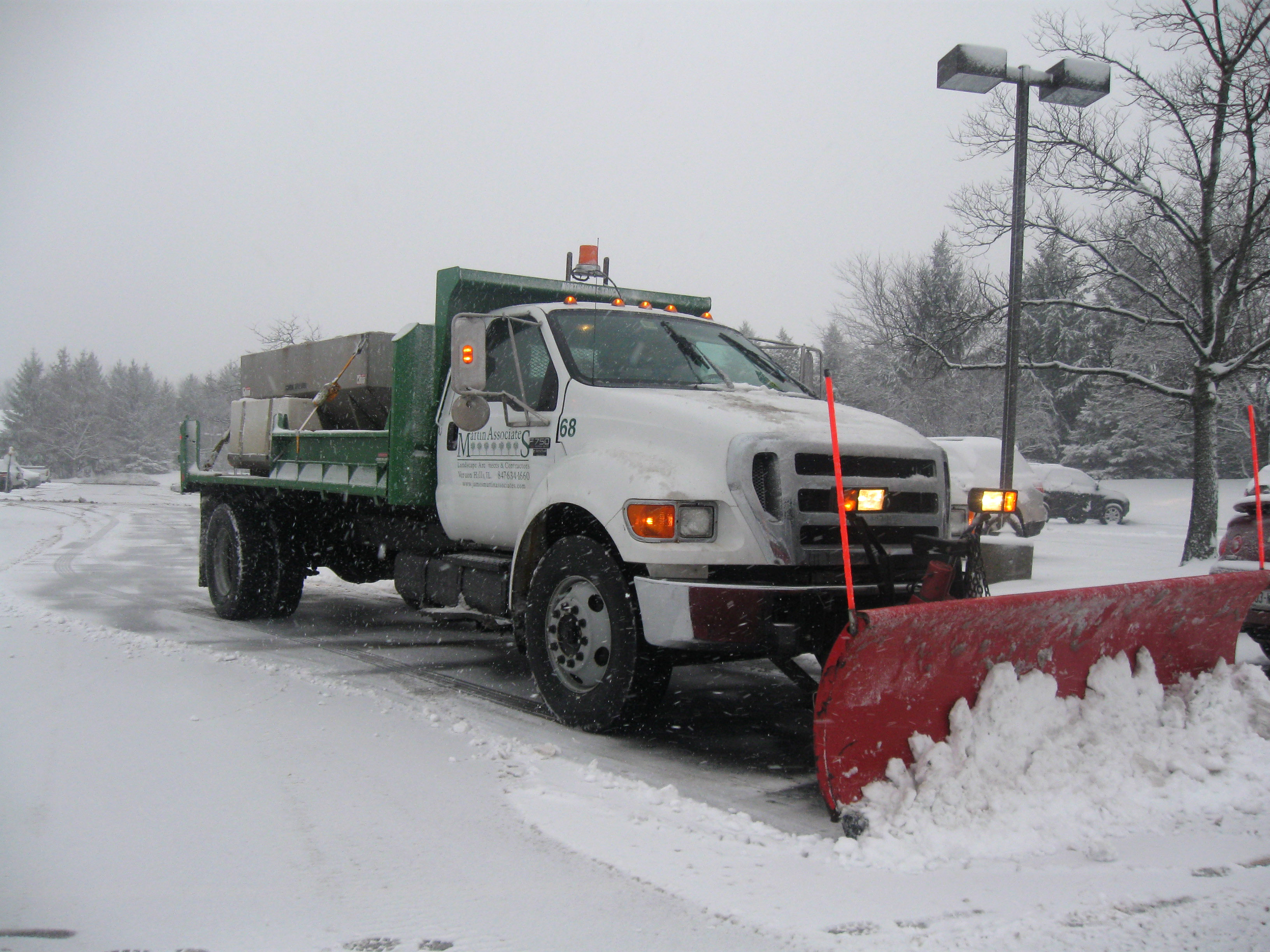 Plow removing snow from parking lot 