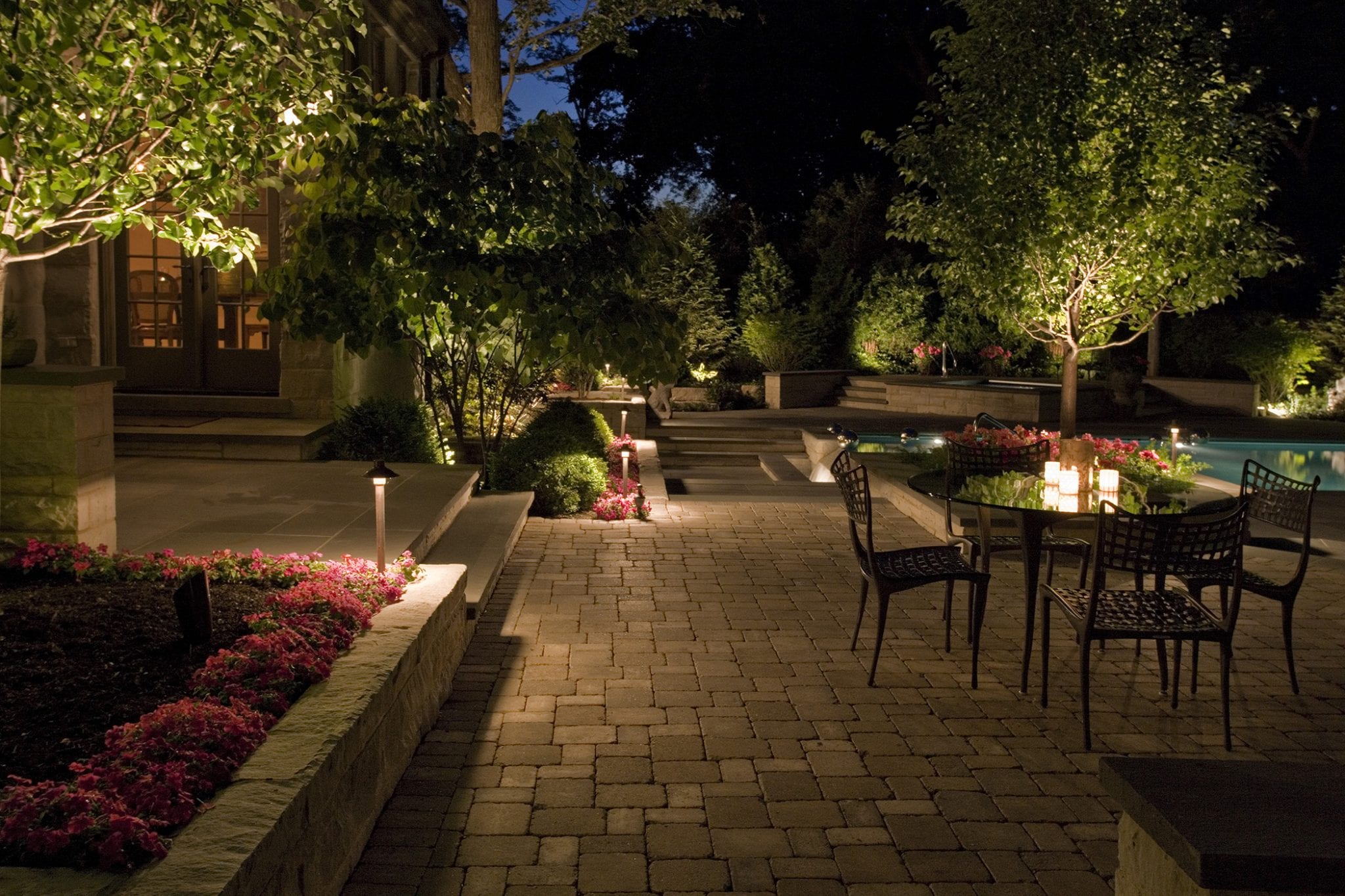 outdoor lighting around backyard pool and concrete paver patio 