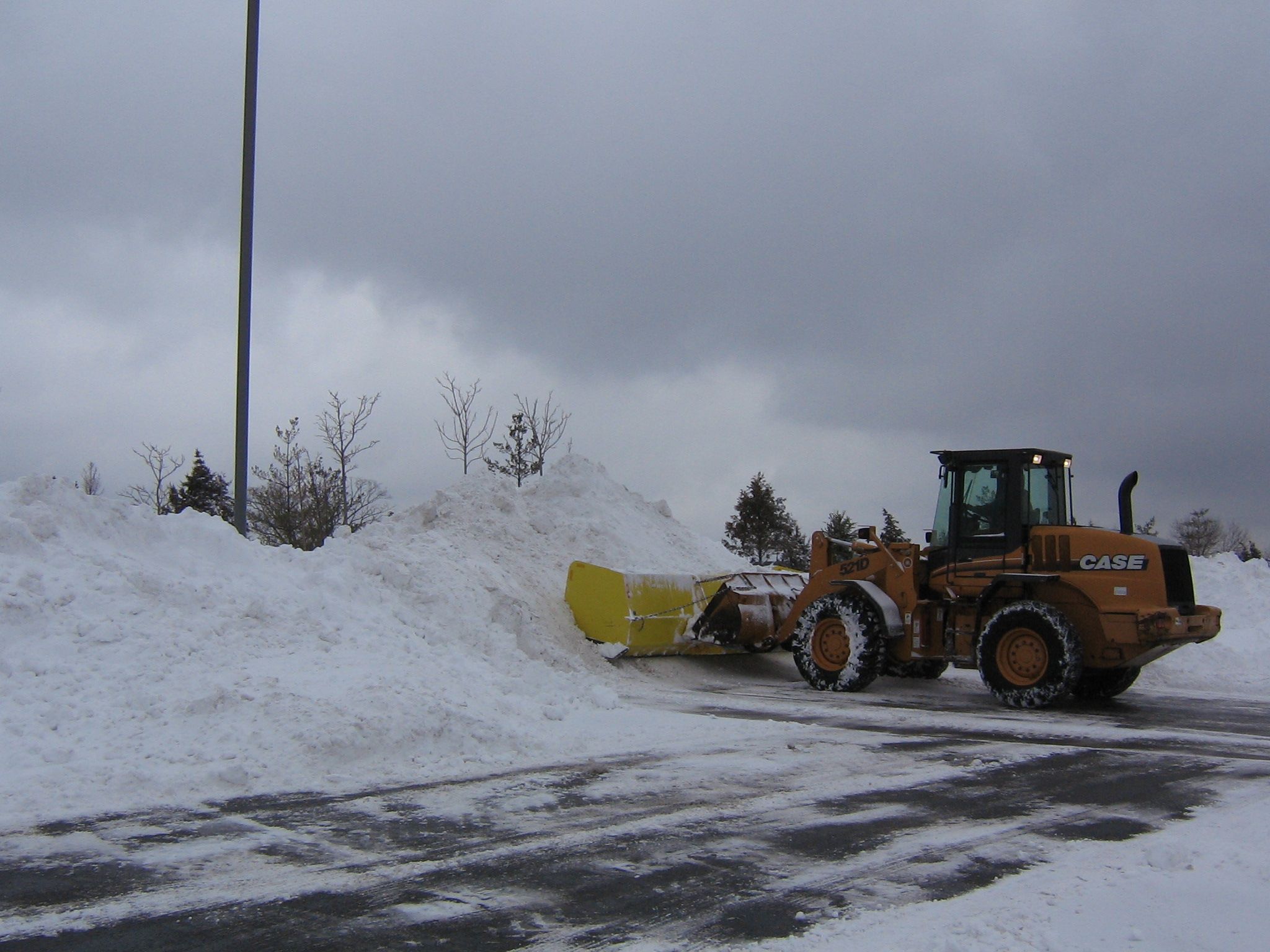 plow removing snow from parking lot 